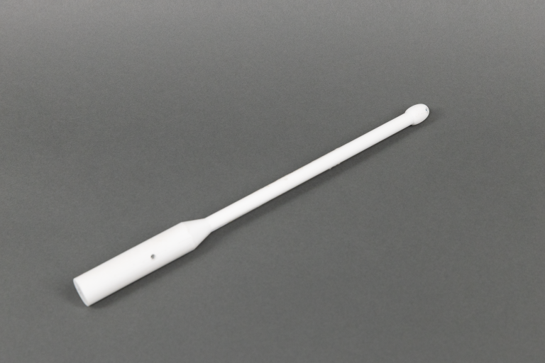 A white plastic swab with a rounded tip and a cylindrical handle is placed diagonally on a plain gray background.