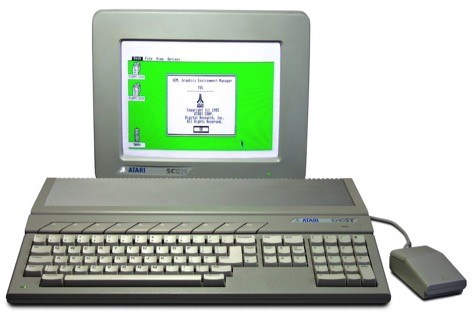 An Atari 1040ST computer with a gray keyboard, rectangular mouse, and a monitor displaying a green and white graphical user interface.