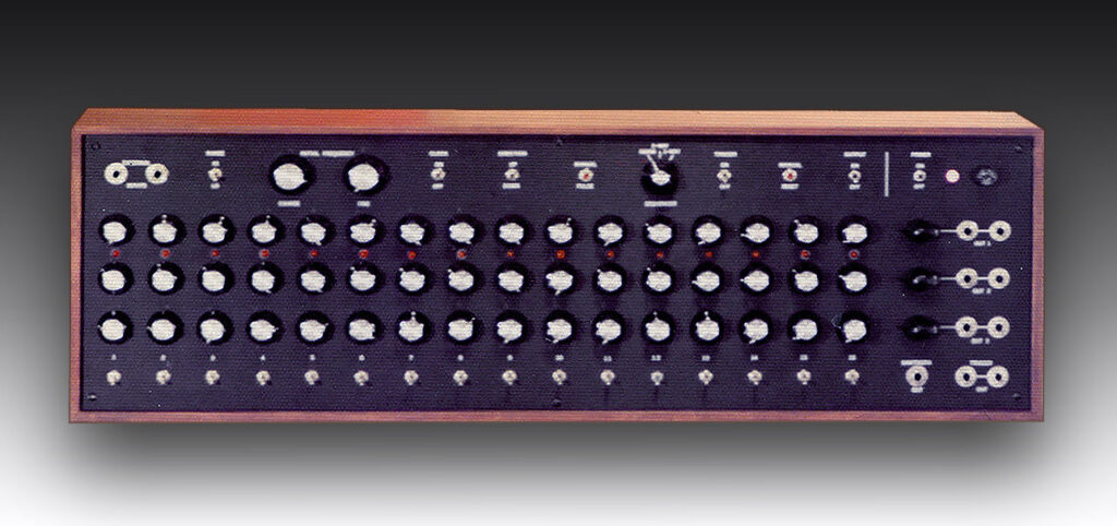 A vintage modular synthesizer panel with numerous knobs, switches, and input/output jacks, housed in a wooden case against a gradient black background.