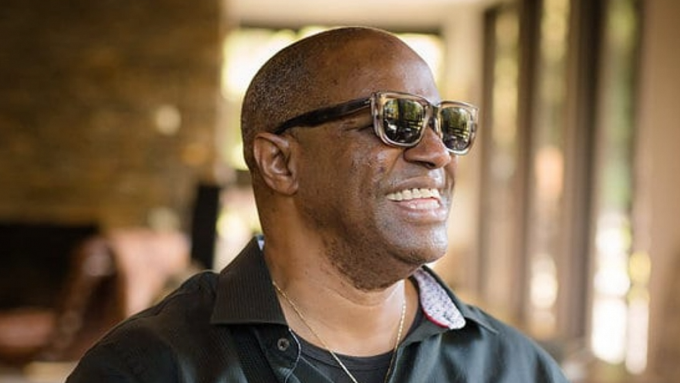 Headshot of Ellis Hall in sunglasses smiling.