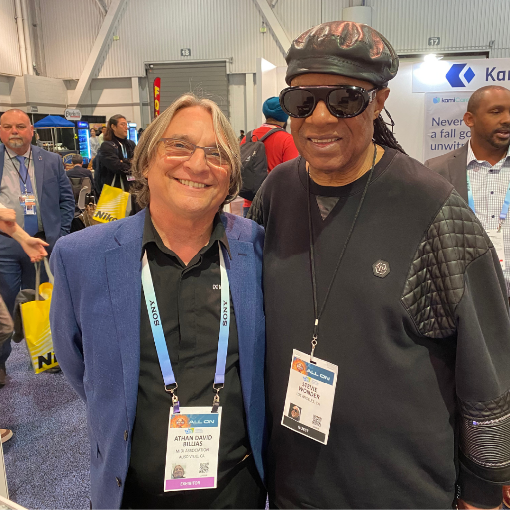 Athan Billias with Stevie Wonder at conference.