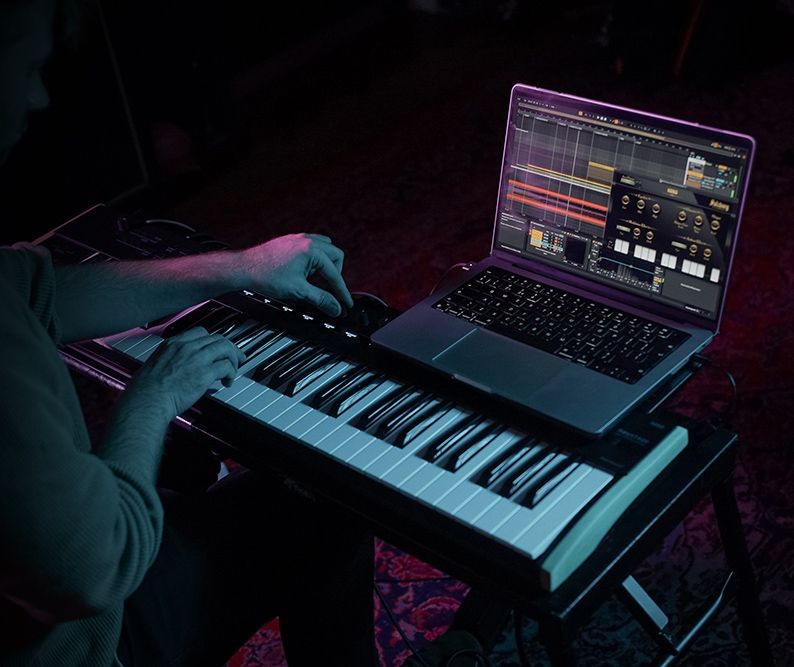 Closeup of someone's hands playing keyboard while capturing on laptop.