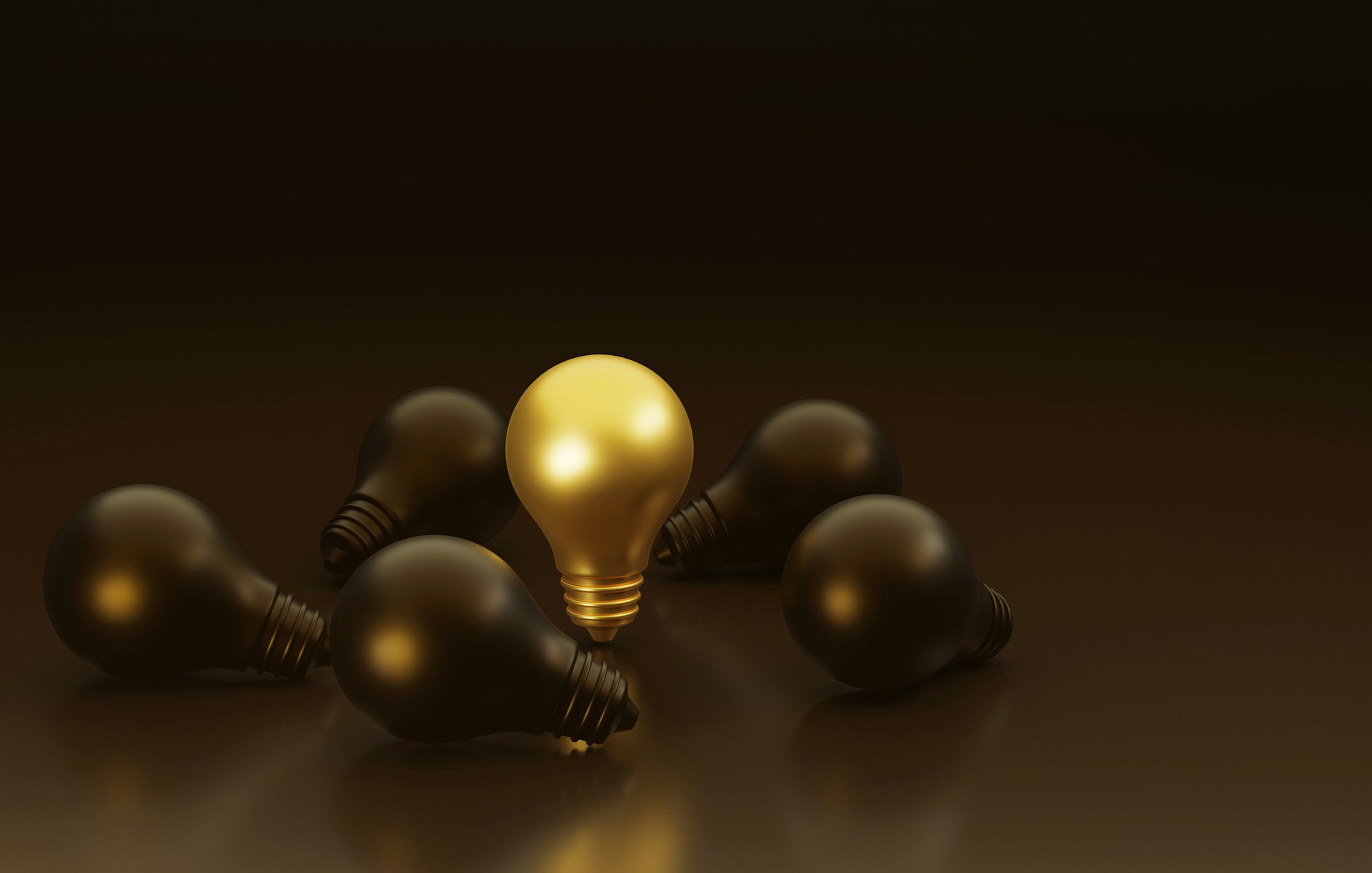 Gold lightbulb among black lightbulbs.