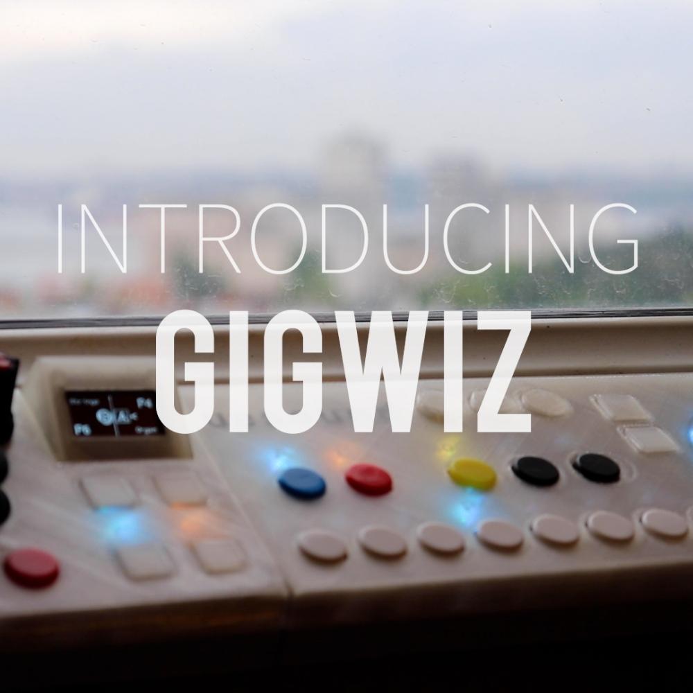 A blurred cityscape seen through a window behind a control panel with buttons and lights. Overlaid text reads: INTRODUCING GIGWIZ.