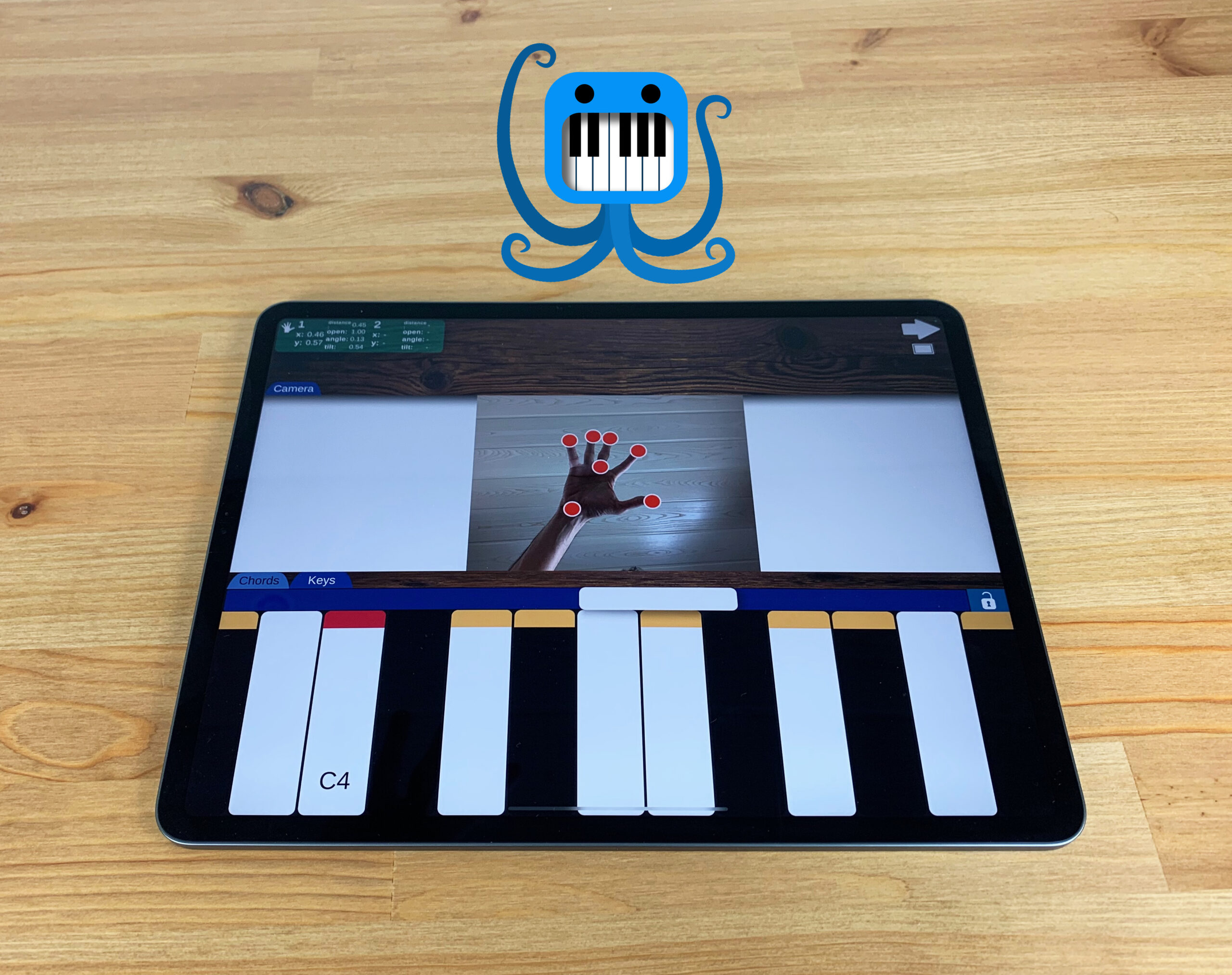 An iPad on a wooden table displays a virtual piano app with a hand-tracking feature, showing a hand with red dots on the fingers above digital piano keys. A blue cartoon octopus holding piano keys is above the iPad.