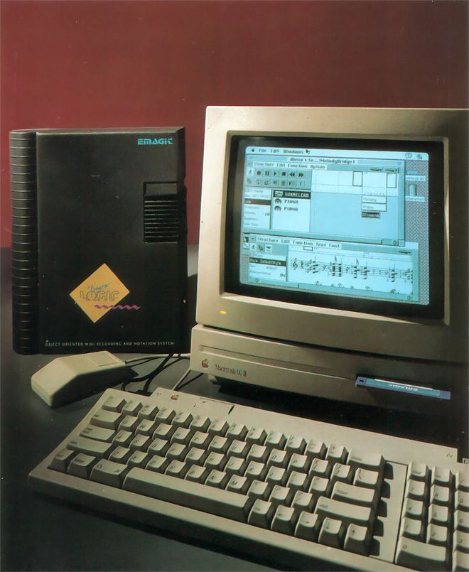 A vintage Macintosh computer with a music editing program displayed on its screen sits on a desk, accompanied by a keyboard, mouse, and a black Emagic software box. The background is a solid dark red.