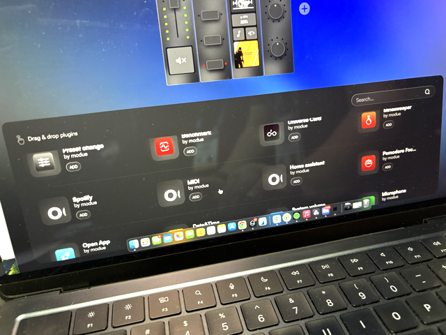 A close-up of a laptop screen displaying a software interface with various app and plugin icons, including Spotify and MIDI. The laptop keyboard and part of the desktop background are also visible.
