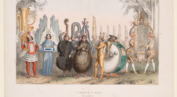 A group of people dressed in elaborate costumes that resemble musical instruments, including a cello, tuba, drum, lyre, and trumpet, stand together outdoors with a background of tall, decorative pipes.