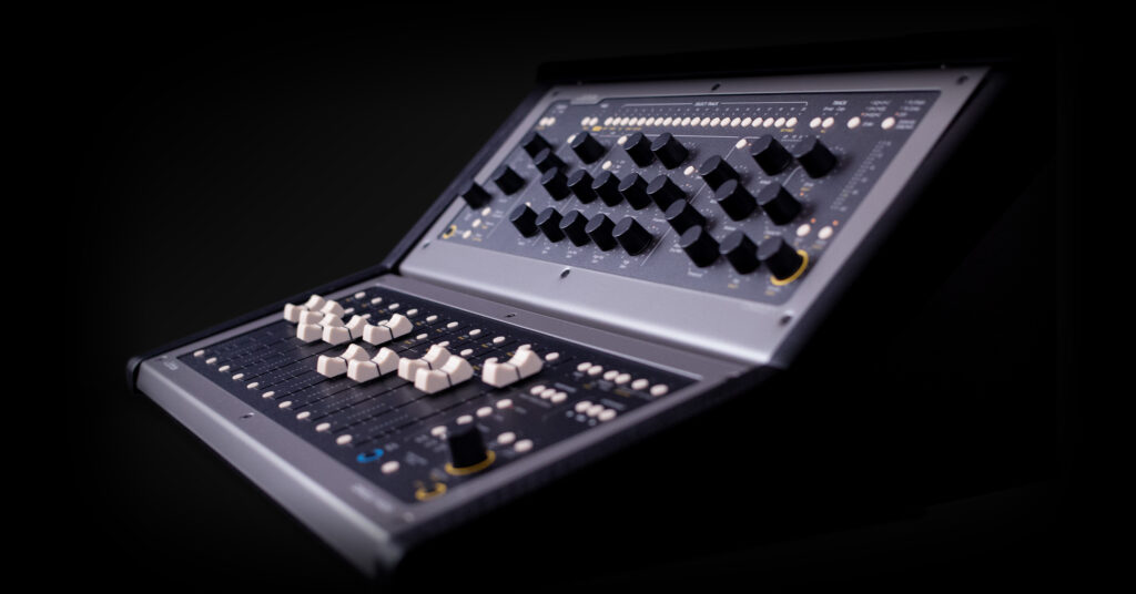 A close-up of an audio mixing console with numerous black and white knobs and sliders, set against a dark background.