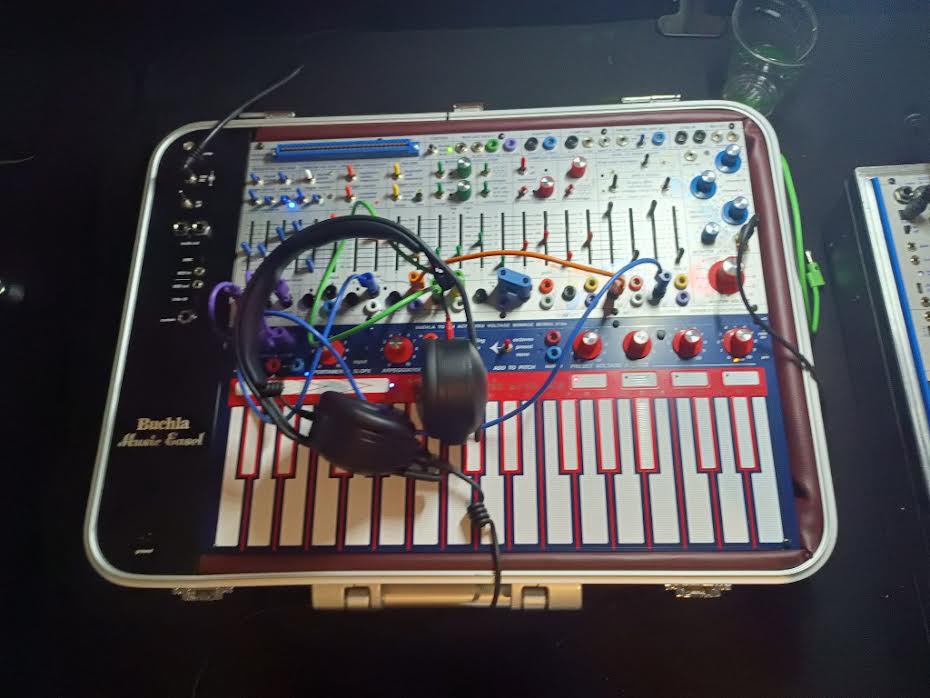 Buchla Music Easel synthesizer with a set of black headphones resting on its keyboard.